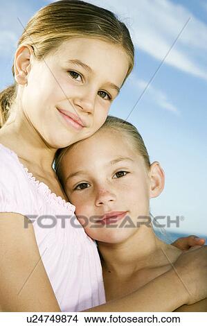 Two young girls embracing View Large Photo Image Picture - Two young girls embracing. Fotosearch