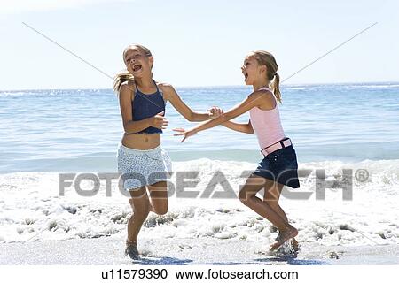 Two young girls playing in the sea View Large Photo Image Stock Image - Two young girls playing in the sea . Fotosearch