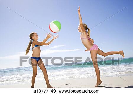 Two young girls playing on the beach View Large Photo Image Stock Photo - Two young girls playing on the beach. Fotosearch