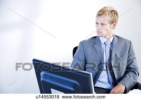 Stock Photo - Businessman looking serious in a modern office. Fotosearch