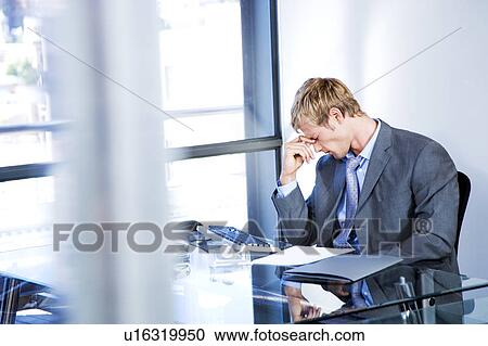 Businessman looking stressed in a modern office View Large Photo Image Stock Image - Businessman looking stressed in a modern office . Fotosearch