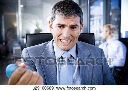 Stock Photo - Businessman squeezing a stress toy. Fotosearch