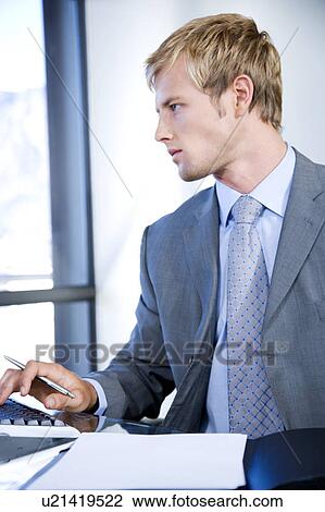 Stock Image - Businessman using a computer in a modern office building. Fotosearch