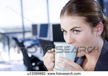 Stock Image - Businesswoman having a tea or coffee break. Fotosearch