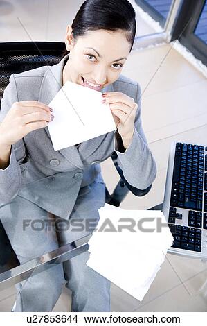 Businesswoman licking and sealing an envelope View Large Photo Image Picture - Businesswoman licking and sealing an envelope. Fotosearch