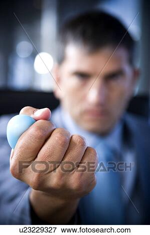 Stock Photo - Close up of a businessman's hand squeezing a stress toy. Fotosearch