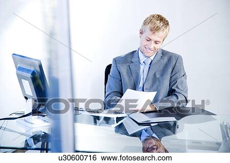 Smiling businessman in a modern office View Large Photo Image Stock Photograph - Smiling businessman in a modern office. Fotosearch