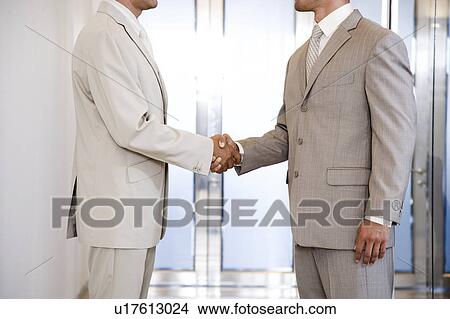 Picture - Two businessman shaking hands, close in crop. Fotosearch