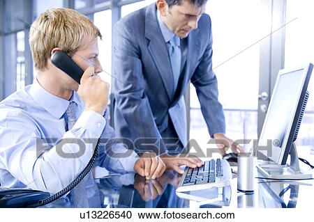 Stock Image - Two businessmen in a modern office. Fotosearch