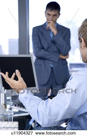 Stock Photo - Two male colleagues in a business meeting . Fotosearch