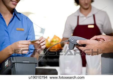 Picture - Close up view of a customer paying by credit card in a supermarket. Fotosearch