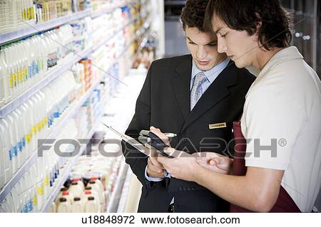 Stock Image - Manager and shop assistant in a supermarket. Fotosearch
