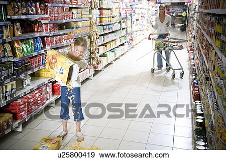Naughty young girl emptying cereal over a supermarket floor View Large Photo Image Stock Photo - Naughty young girl emptying cereal over a supermarket floor. Fotosearch
