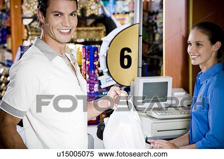 Stock Photography - Portrait of a customer and supermarket checkout assistant. Fotosearch