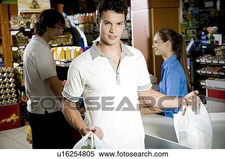 Portrait of a customer and supermarket checkout assistant View Large Photo Image Stock Photography - Portrait of a customer and supermarket checkout assistant. Fotosearch