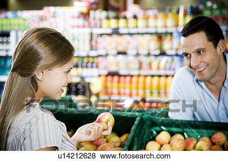 Supermarket shop assistant flirting with a customer View Large Photo Image Stock Photo - Supermarket shop assistant flirting with a customer. Fotosearch