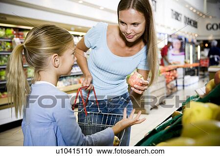 Young girl and mother selecting fruit in a supermarket View Large Photo Image Stock Image - Young girl and mother selecting fruit in a supermarket. Fotosearch