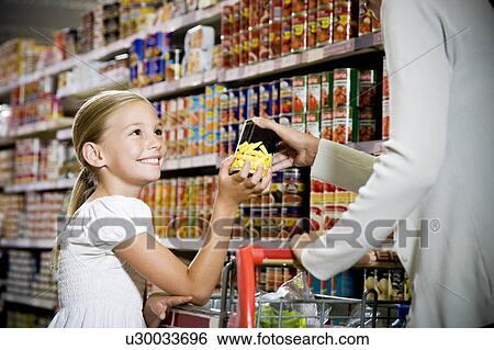 Young girl helping her mother in a supermarket View Large Photo Image Stock Photograph - Young girl helping her mother in a supermarket. Fotosearch