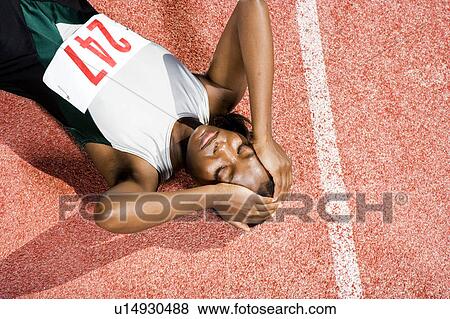 Female athlete resting on a running track View Large Photo Image Stock Photo - Female athlete resting on a running track. Fotosearch