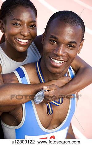 Stock Image - Portrait of a female and athletes celebrating their win. Fotosearch