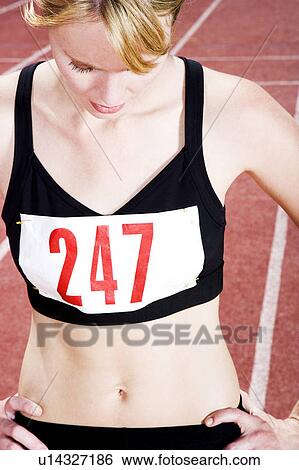Stock Photograph - Portrait of a female athlete resting on the running track. Fotosearch