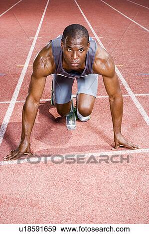 Stock Photo - Portrait of a male athlete in the starting blocks. Fotosearch