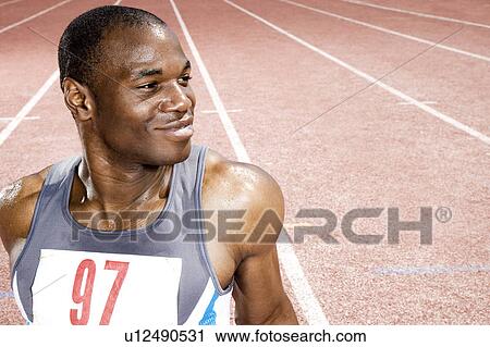 Portrait of a male athlete resting sitting on a running track View Large Photo Image Stock Image - Portrait of a male athlete resting sitting on a running track. Fotosearch