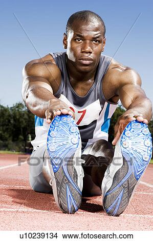 Picture - Portrait of a male athlete stretching in a warm up. Fotosearch