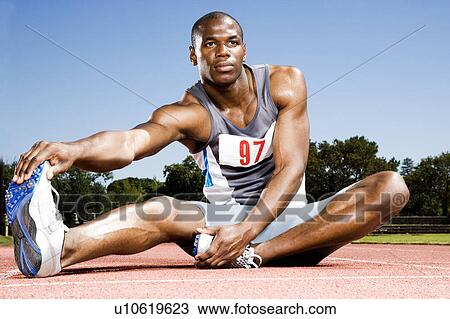 Portrait of a male athlete warming up and stretching View Large Photo Image Stock Image - Portrait of a male athlete warming up and stretching. Fotosearch