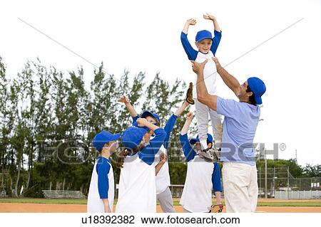 若い少年 ある 持ち上げられる によって 小さいリーグ野球 コーチ ストックイメージ U1923 Fotosearch