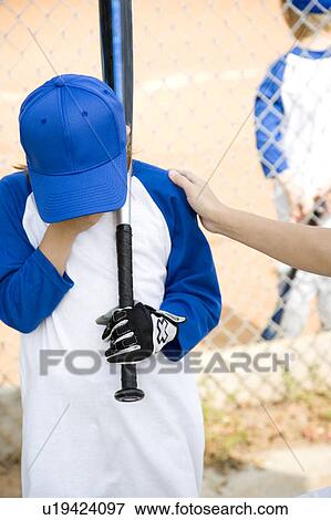 Adult comforting child at little league baseball game View Large Photo Image Stock Photo - Adult comforting child at little league baseball game. Fotosearch