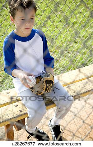 Boy in baseball gear sitting on a bench View Large Photo Image Stock Photo - Boy in baseball gear sitting on a bench. Fotosearch