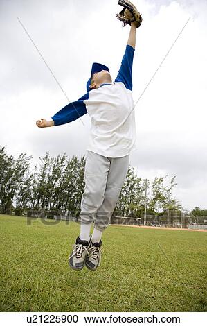 Stock Image - Boy jumping to catch baseball. Fotosearch