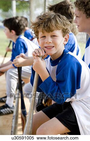 Boy sitting on bench with little league baseball team View Large Photo Image Stock Photography - Boy sitting on bench with little league baseball team . Fotosearch