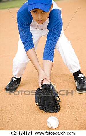 Boy stooping to pick up baseball View Large Photo Image Stock Image - Boy stooping to pick up baseball. Fotosearch