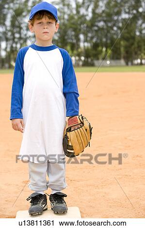 Stock Image - Portrait young boy on baseball base. Fotosearch