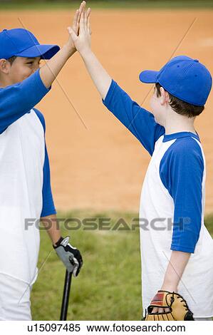 two boys giving a high five at baseball match View Large Photo Image Stock Photography - two boys giving a high five at baseball match. Fotosearch
