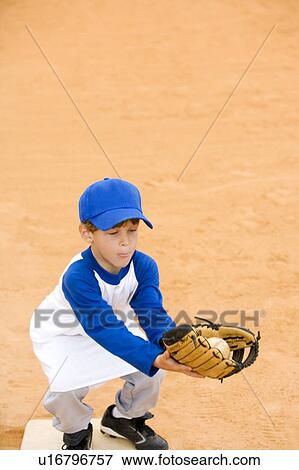 Stock Photo - Young boy catching baseball. Fotosearch
