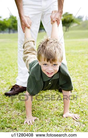 Boy walking on hands father holding legs View Large Photo Image Stock Photo - Boy walking on hands father holding legs. Fotosearch