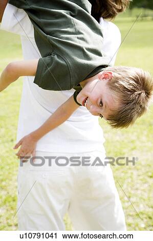 father throwing son over shoulder in the park View Large Photo Image Stock Image - father throwing son over shoulder in the park. Fotosearch