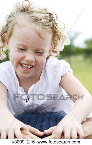 Little girl playfighting with father on grass View Large Photo Image Stock Photograph - Little girl playfighting with father on grass. Fotosearch