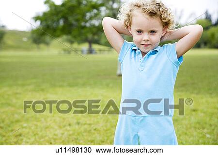 Stock Image - Little girl standing in the park. Fotosearch