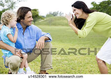 Mother taking photograph of husband and child View Large Photo Image Stock Image - Mother taking photograph of husband and child. Fotosearch