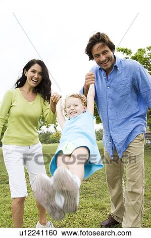 parents playing with their daughter in the park View Large Photo Image Stock Image - parents playing with their daughter in the park. Fotosearch