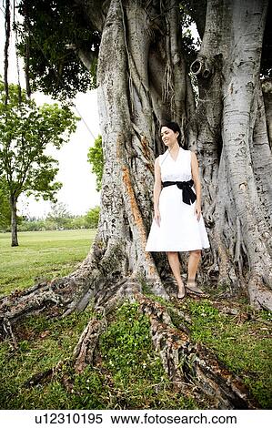 woman standing in front of tree View Large Photo Image Stock Photography - woman standing in front of tree. Fotosearch