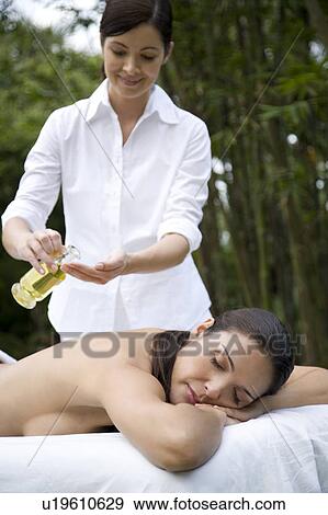 Hispanic woman receiving a massage in a tropical setting View Large Photo Image Stock Photo - Hispanic woman receiving a massage in a tropical setting. Fotosearch