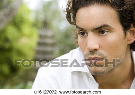 Portrait of a serious looking man in a tropical garden. View Large Photo Image Stock Image - Portrait of a serious looking man in a tropical garden. . Fotosearch