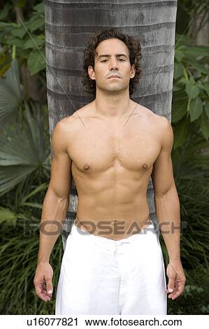 Portrait of a toned muscular man standing in a garden wearing white linen trousers View Large Photo Image Stock Image - Portrait of a toned muscular man standing in a garden wearing white linen trousers. Fotosearch