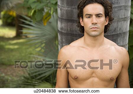 Portrait of a toned muscular man standing in a garden View Large Photo Image Stock Photo - Portrait of a toned muscular man standing in a garden. Fotosearch