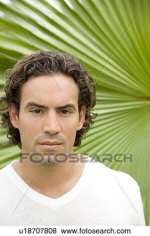 Stock Photo - Portrait of an adult man in a tropical garden. . Fotosearch